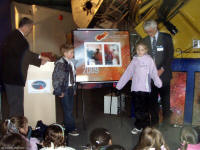 Kevin Pearson and Greg Fahlman with two Lochside students unveil the stamps